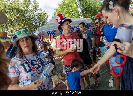 Austin, Texas, États-Unis, 4 juillet 2024. Les voisins socialisent pendant la parade annuelle du quartier de Barton Hills le 4 juillet. Quelques centaines de résidents ont parcouru le parcours du défilé de 1/2 km jusqu'au terrain de jeu de l'école primaire, où ils ont dégusté des biscuits, de la pastèque et de la crème glacée. Crédit : Bob Daemmrich/Alamy Live News Banque D'Images