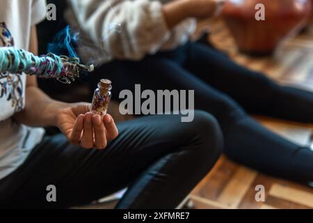 Gros plan des mains faisant un rituel avec de la lavande et de la cannelle. Photo de haute qualité Banque D'Images