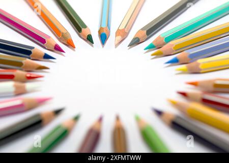 Crayons colorés disposés dans une forme ronde sur un fond blanc. Idéal pour les concepts liés à la créativité, l'art, l'amour et le design coloré. Banque D'Images