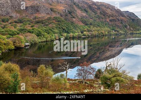 Réflexions à Llyn Dinas avec des pêcheurs dans un bateau, vallée de Nant Gwynant, Beddgelert, Snowdonia, pays de Galles du Nord, Royaume-Uni, octobre. Banque D'Images