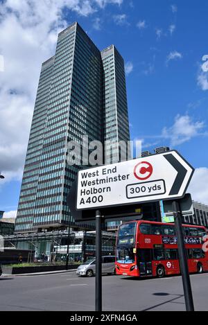 Panneau de direction avec symbole de péage de congestion, bus et tour Euston en arrière-plan, Euston Road, Central London, UK, mars 2016. Banque D'Images