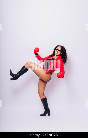 Femme africaine oversize avec des gants de boxe sur fond de studio, beau boxer féminin à la peau foncée Banque D'Images