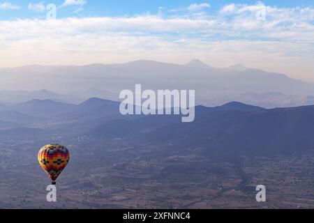 Vol en montgolfière au-dessus des montagnes et du paysage du Mexique avec le volcan du mont Popocatepetl au loin, Teotihuacan, voyage au Mexique. Banque D'Images