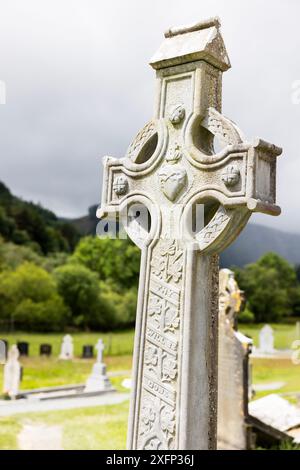 Gros plan d'une pierre tombale à croix celtique dans le cimetière du monastère St Kevin à Glendalough, comté de Wicklow, Irlande. Banque D'Images