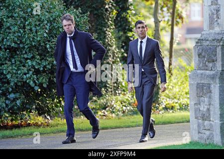 Photo du dossier datée du 21/10/2021 du conseiller spécial Liam Booth-Smith (à gauche) arrive avec le chancelier de l'Échiquier Rishi Sunak pour les funérailles de James Brokenshire à l'église St John the Evangelist à Bexley, au sud-est de Londres. Sunak a récompensé son bras droit Liam Booth-Smith avec une pairie, annoncée moins d’une heure avant la fermeture des bureaux de vote lors des élections générales. Lord Booth-Smith, qui avait été le chef de cabinet de M. Sunak à Downing Street, a été inclus dans la liste des distinctions honorifiques de dissolution du premier ministre. Date d'émission : jeudi 4 juillet 2024. Banque D'Images