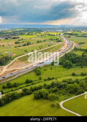 Vue d'un grand chantier à côté d'une route à travers des champs verts et sous un ciel nuageux, autoroute A8, Kieselbronn, Allemagne Banque D'Images