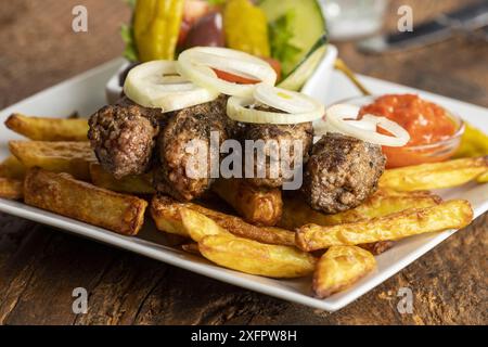 Cevapcici avec frites et rondelles d'oignon Banque D'Images