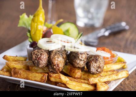 Cevapcici avec frites et rondelles d'oignon Banque D'Images