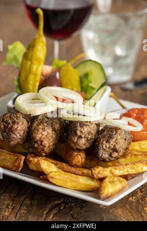 Cevapcici avec frites et rondelles d'oignon Banque D'Images