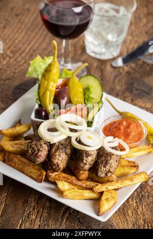 Cevapcici avec frites et rondelles d'oignon Banque D'Images