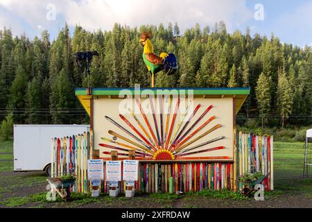 Structure décorée de skis sur la façade et d'un coq ornemental géant sur le toit, forêt de pins en arrière-plan, Pagosa Springs, Colorado, USA. Banque D'Images