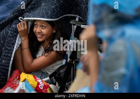 Washington, États-Unis. 04 juillet 2024. Arianna Ciueadreal, 11 ans, se met à l'abri pendant la pluie tôt près du Washington Monument sur le National Mall avant les célébrations du 248e jour de l'indépendance de l'Amérique à Washington, DC, le jeudi 4 juillet 2024. Photo de Ken Cedeno/UPI crédit : UPI/Alamy Live News Banque D'Images