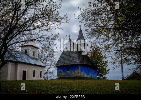 Europe, Roumanie. Comté de Maramures. Église Aspra Village au coucher du soleil. Banque D'Images