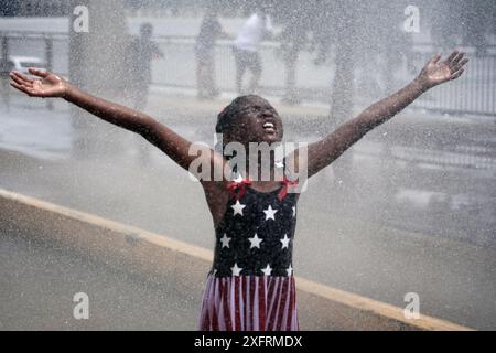 Louis, États-Unis. 04 juillet 2024. Une jeune fille profite de l'eau fraîche d'un camion de pompiers comme un soulagement des températures de 90 degrés lors de l'événement Celebrate-équipés Louis à offert Louis le jeudi 4 juillet 2024. Photo de Bill Greenblatt/UPI crédit : UPI/Alamy Live News Banque D'Images