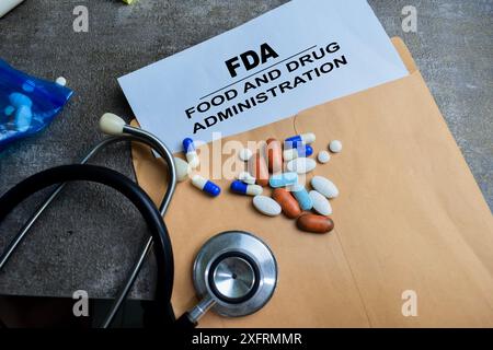 Tampon en caoutchouc à poignée rouge et FDA - texte de la Food and Drug Administration au-dessus de l'enveloppe brune isolée sur fond de bois Banque D'Images