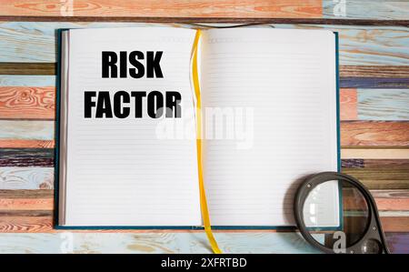 Bloc-notes avec facteur de risque de texte sur fond vintage avec loupe Banque D'Images