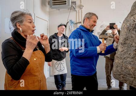 L’artiste aka Hoeegh regarde le roi Frederik X tenter de sculpter la prochaine pierre commémorative lors d’une visite à un atelier à Nuuk, au Groenland, le jeudi 4 juillet 2024. L’atelier travaille sur une pierre commémorative pour l’explorateur polaire Arnarulunnguaq. Seule femme exploratrice polaire, elle participe à la célèbre 5e expédition de Thulé de 1921 à 1924. L'artiste derrière la pierre commémorative est alias Hoeegh, qui a précédemment réalisé, entre autres, un portrait timbré de la reine Margrethe. Le couple royal visite officiellement le Groenland du 29 juin au 6 juillet 2024. La visite commence dans la baie de Disko et le ro Banque D'Images