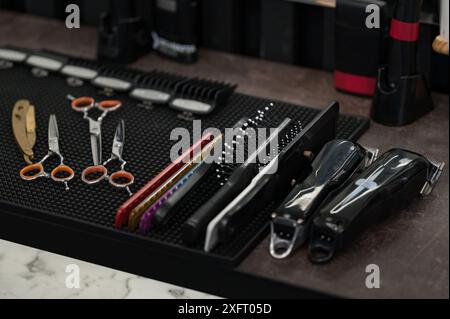 Outils de barbiers pour les coupes de cheveux d'hommes disposés sur une table de gros plan. Ensemble de ciseaux et rasoir dangereux pour les coupes de cheveux en gros plan. Banque D'Images