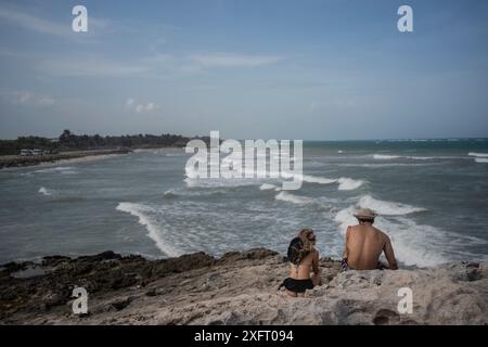 Tulum, Mexique. 04 juillet 2024. Un couple regarde la mer avant l'arrivée de l'ouragan Beryl. L’ouragan atlantique devrait atteindre la côte est de la péninsule de Yucatán avec l’ouragan force 1 vendredi soir. Les experts s'attendent à de forts vents et des précipitations ainsi qu'à de dangereuses ondes de tempête. Crédit : Felix Marquez/dpa/Alamy Live News Banque D'Images