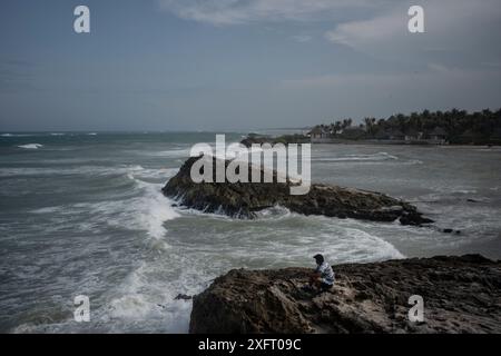 Tulum, Mexique. 04 juillet 2024. Un homme regarde la mer avant l'arrivée de l'ouragan Beryl. L’ouragan atlantique devrait atteindre la côte est de la péninsule de Yucatán avec l’ouragan force 1 vendredi soir. Les experts s'attendent à de forts vents et des précipitations ainsi qu'à de dangereuses ondes de tempête. Crédit : Felix Marquez/dpa/Alamy Live News Banque D'Images