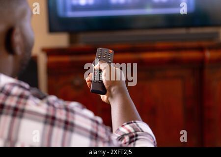 Tenant la télécommande, homme regardant la télévision à la maison dans le salon Banque D'Images