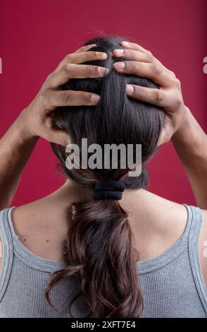 la tête d'une femme blanche, avec ses cheveux en queue de cheval, est tenue par les mains d'un homme noir. Cela représente l'inclusivité, la fluidité du genre, le non-binarisme et le p Banque D'Images