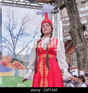 Almaty, Kazakhstan - 21 mars 2024 : Portrait de mignonne fille asiatique dans des vêtements nationaux kazakhs stylisés lors d'un défilé de mode pendant la célébration de la s. Banque D'Images