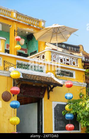 Hoi an (Hoian), Vietnam - 11 avril 2018 : pittoresque vieux bâtiment jaune traditionnel décoré de lanternes de soie dans la ville antique. Banque D'Images