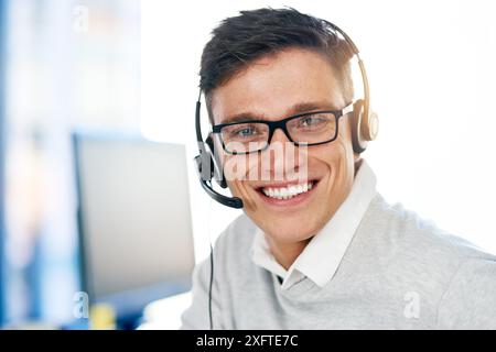 Homme, casque et heureux dans le lieu de travail avec portrait comme assistant virtuel, personnel de communication et employé. Personne masculine, sourire et microphone avec Banque D'Images