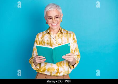 Portrait photo de la femme senior attrayante lu livre habillé élégants vêtements élégants isolés sur fond de couleur bleue Banque D'Images