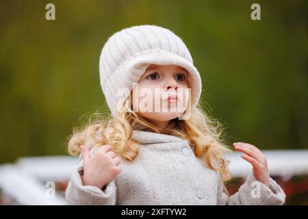 Portrait d'une vilaine petite fille qui a tiré un chapeau sur son visage Banque D'Images