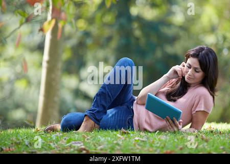 35 ans woman with digital tablet in park. Donostia. San Sebastian. Gipuzkoa. Pays Basque, Espagne. Banque D'Images