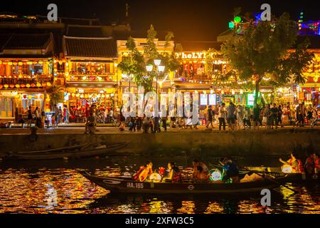 Vue de la rue dans la ville antique de Hoi an la nuit avec des bateaux lanternes sur la rivière Hoai, au Vietnam Banque D'Images