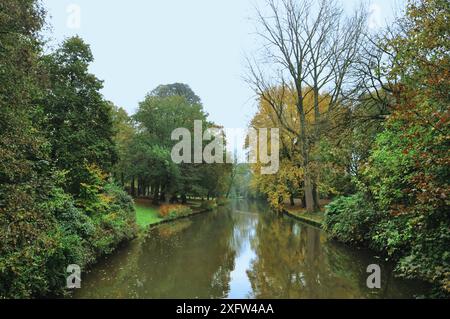 30-10-2014 Bruges, Belgique - Un canal à Bruges traverse une végétation luxuriante par temps nuageux Banque D'Images