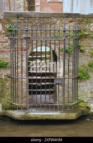 30-10-2014 Bruges, Belgique - Un accès au canal fermé par une porte avec des escaliers menant à une maison Banque D'Images