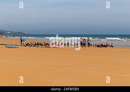 Un cours de surf s’échauffant sur la plage Playa de Berria à Santona, dans le nord de l’Espagne Banque D'Images