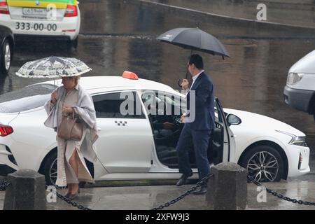 Saint-Pétersbourg, Russie. 04 juillet 2024. Les gens sortent d'un taxi pendant la pluie abondante le long de la route dans le centre de parfait Petersburg. (Photo de Maksim Konstantinov/SOPA images/SIPA USA) crédit : SIPA USA/Alamy Live News Banque D'Images