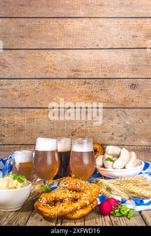 L'Oktoberfest propose une cuisine traditionnelle bavaroise pour les vacances, des saucisses avec bretzels, de la choucroute, du verre à bière et des tasses sur un bac éclairé au soleil en bois Banque D'Images