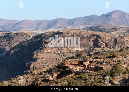 Village au sommet de la montagne de maisons traditionnelles en pierre, entre Semonkong et près de Quthing, Lesotho. Août 2017 Banque D'Images