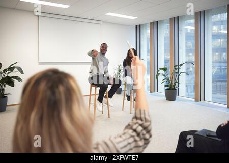 Homme d'affaires pointant à collègue pour poser une question lors de la réunion dans le bureau Banque D'Images