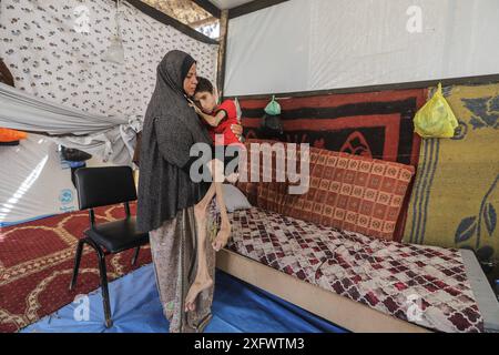 Un garçon palestinien, Ahmed Al-Najjar, 21 ans, souffre de malnutrition et d'atrophie cérébrale Un garçon palestinien, Ahmed Al-Najjar, 21 ans, souffre de malnutrition et d'atrophie cérébrale. Il est allongé sur son lit à l'intérieur d'une tente dans un centre pour abriter les déplacés à Al-Zawaida, dans le centre de la bande de Gaza, le 5 juillet 2024. Al-Najjar, qui pèse 11 kilos, vit avec sa famille dans des conditions de vie difficiles et un manque de nécessités de la vie. Photo de Omar Ashtawy apaimages Al-Zawayda bande de Gaza territoire palestinien 050724 Zawaida OSH 0025 Copyright : xapaimagesxOmarxAshtawyxxapaimagesx Banque D'Images