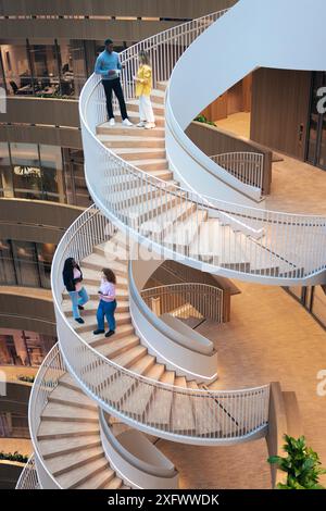 Vue en angle élevé des employés parlant sur un escalier en colimaçon au bureau Banque D'Images