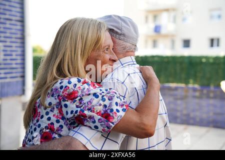 Une famille s'embrasse. Un père et sa fille serrés sur la terrasse Banque D'Images