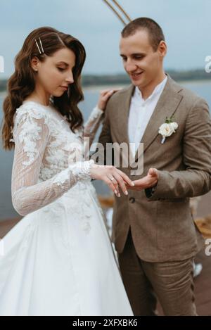 la première danse de mariage de la mariée et mariée sur la jetée près de la rivière, dans le contexte de l'arc de mariage Banque D'Images