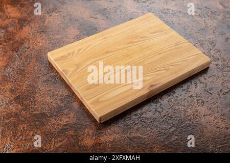 Planche à découper sur une table de cuisine. Fond culinaire. Planche à découper en bois vide, espace d'affichage du produit. Banque D'Images