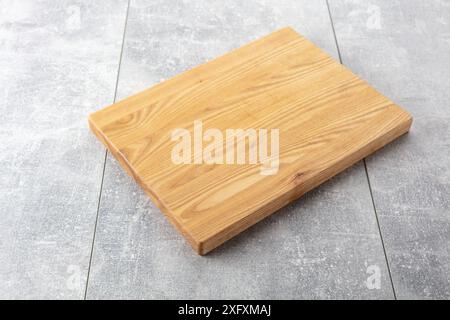 Planche à découper sur une table de cuisine. Fond culinaire. Planche à découper en bois vide, espace d'affichage du produit. Banque D'Images