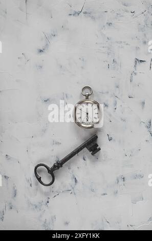 Vieille clé et montre de poche en argent sur fond blanc peint à la main Banque D'Images