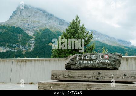 Grindelwald, Suisse - 20 août 2023 : le logo de la ville est écrit sur un rocher avec le célèbre mont Eiger en arrière-plan. Concept de touris Banque D'Images