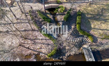 Photographie par drone de petits barrages, cascades et pont piétonnier pendant la journée ensoleillée du printemps Banque D'Images