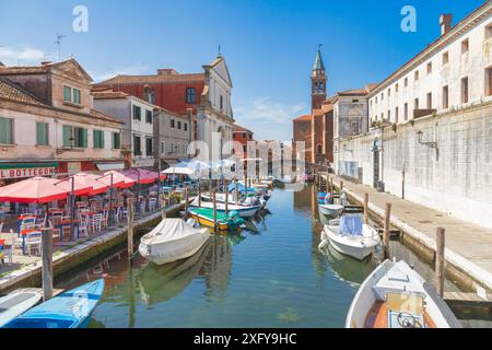 La veine du canal avec des bateaux multicolores amarrés, l'église de Filippini, le clocher de l'église de San Giacomo Apostolo, Chioggia, ville de la ville métropolitaine de Venise, Vénétie, Italie Banque D'Images